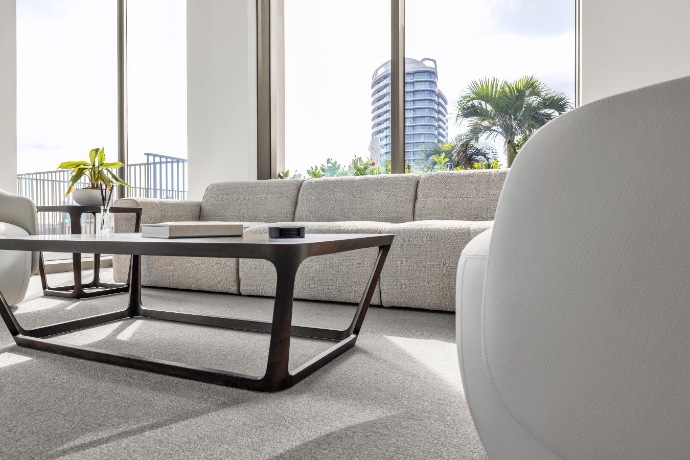 One Flagler - Walnut wood coffee table and cream sofa seat detail - BHouse Design Florida